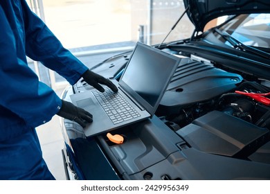 Car service, repair, maintenance concept - auto mechanic man or Smith writing to the clipboard at warehouse workshop, technician doing the checklist for repairs engine a car in the garage with laptop. - Powered by Shutterstock