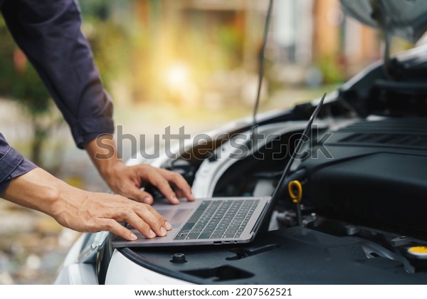 car service, repair, maintenance concept -\
Asian auto mechanic man or Smith writing to the clipboard at\
workshop warehouse, technician doing the checklist for repair\
machine a car in the\
garage,banner