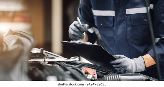 Car service, repair, maintenance concept,auto mechanic man or Smith writing to the clipboard at workshop, technician doing the checklist for repair machine a car in the garage,banner. - Powered by Shutterstock