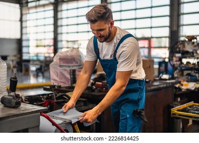 Car service, repair, maintenance and people concept - auto mechanic man or smith cleaning his hands with wipe at workshop - Powered by Shutterstock