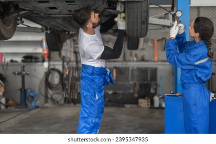 Car service technicians examine, analyze, diagnose wheel and tire issues in garage workshop. Using precise tools to detect, troubleshoot, repair problems, ensuring optimal balancing and alignment. - Shutterstock ID 2395347935