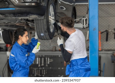 Car service technicians examine, analyze, diagnose wheel and tire issues in garage workshop. Using precise tools to detect, troubleshoot, repair problems, ensuring optimal balancing and alignment. - Shutterstock ID 2395347937