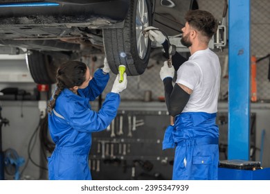Car service technicians examine, analyze, diagnose wheel and tire issues in garage workshop. Using precise tools to detect, troubleshoot, repair problems, ensuring optimal balancing and alignment. - Shutterstock ID 2395347939