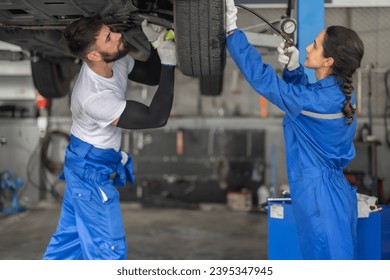 Car service technicians examine, analyze, diagnose wheel and tire issues in garage workshop. Using precise tools to detect, troubleshoot, repair problems, ensuring optimal balancing and alignment. - Shutterstock ID 2395347945