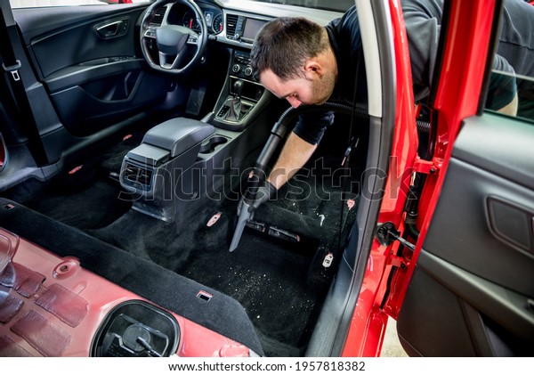 Car service worker cleaning car interior with a
vacuum cleaner