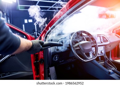 Car Service Worker Cleans Interiror With Steam Cleaner