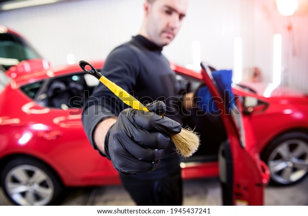 Car\
service worker cleans interiror with special\
brush