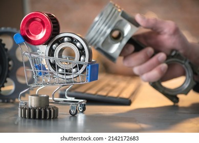 Car service worker with a engine piston in hand with the automobile shop shopping cart with the car spare parts on the foreground close up.  - Shutterstock ID 2142172683