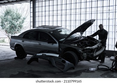 Car service worker repairs restores car - Shutterstock ID 2110799165