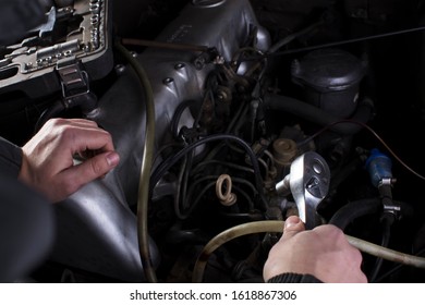 Car services. Hands of a mechanic with a tool. Car engine repair.