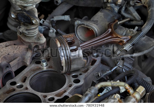 Car servicing, old piston at engine block\
after disassembly