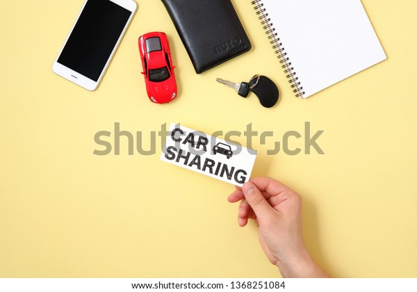 Car sharing concept. Human hand holding text sign
