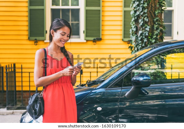 Car sharing mobile\
phone tech lifestyle. Ridesharing app Asian woman using cellphone\
for travel vacation.