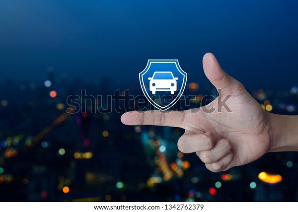 Car with shield flat icon on finger over blur\
colorful night light city tower and skyscraper, Business automobile\
insurance concept