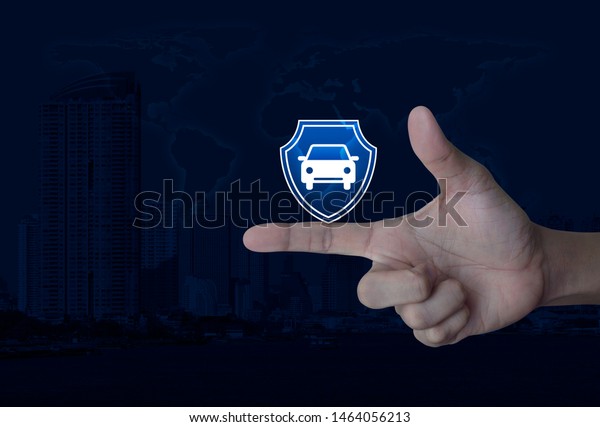 Car with shield flat icon on\
finger over world map, modern city tower and skyscraper, Business\
automobile insurance concept, Elements of this image furnished by\
NASA