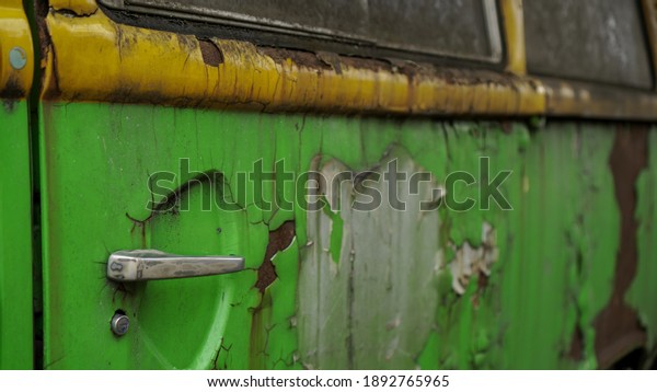 Car\
side door with rusty car background near the\
house