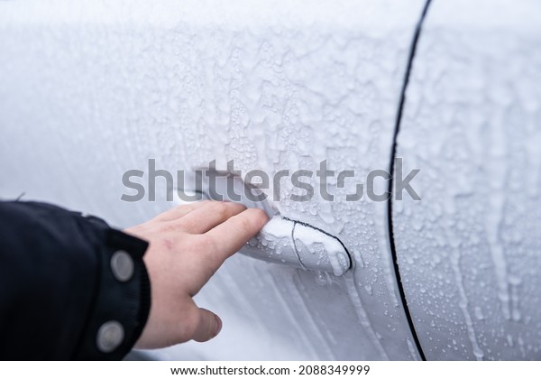 Car side\
mirror covered with ice . covered car . Windshield Frozen car\
winter driving . Frosty patterns on a completely headlights with\
icicles and snow in winter season scraping\
ice