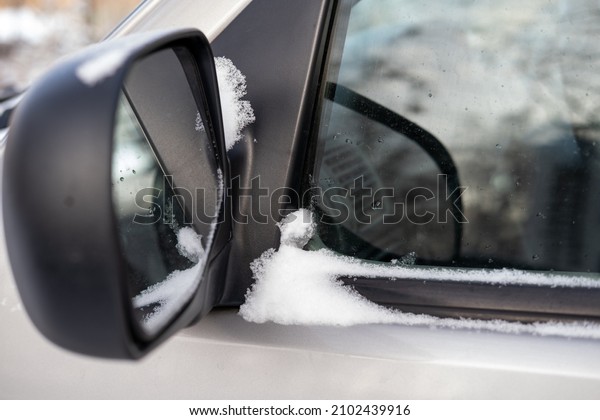Car\
side mirror for review. Snowy weather, winter\
season.