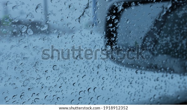 car side window in\
specks of wet melting snowflakes, through which the side mirror is\
blurred, the mood of a traveler or driver looking through the\
window at a rainy street