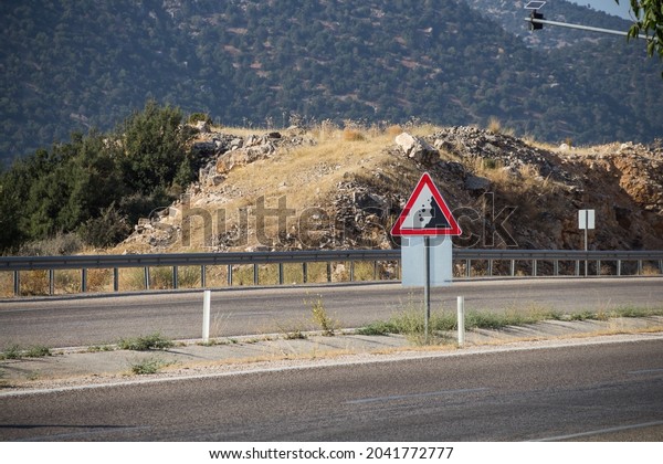 car sign Falling stones on the\
road in Turkey, be careful, stones may fall from the\
mountain