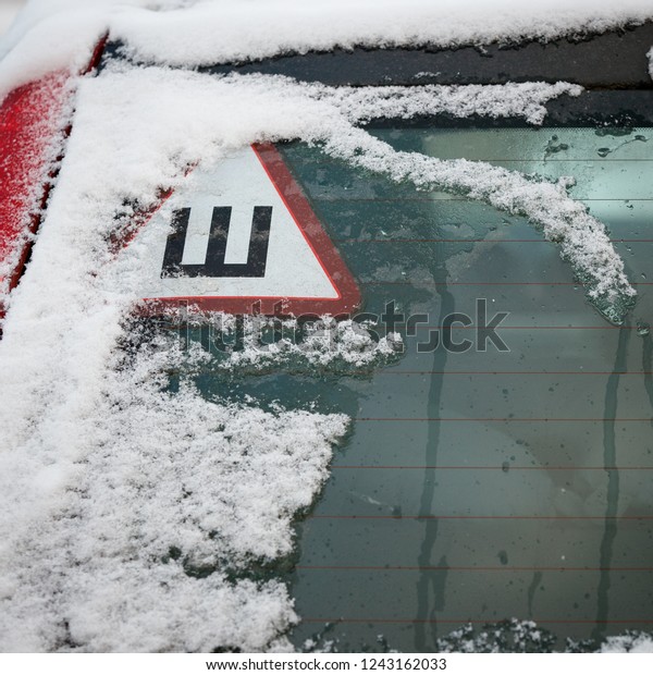 Car Sign studded tires on the rear window of\
the car. Safe movement on snowy\
roads