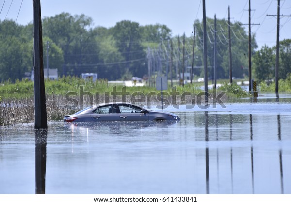 A\
car sits stranded after getting stuck on a flooded\
road
