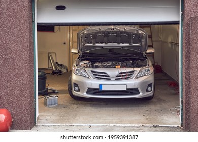 Car In A Small Repair Shop Garage With Open Hood, Engine Diagnostics