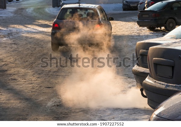 Car smog and air pollution from the exhaust\
pipe in the city in the winter.  Smoke in the rays of the sunset.\
The concept of the need to switch from internal combustion engines\
to electric vehicles.