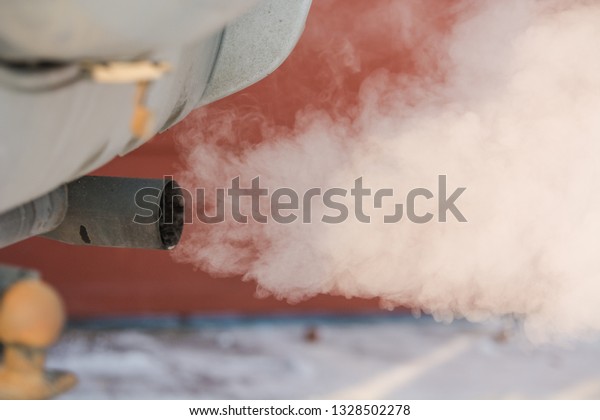 The car smokes in the winter. Smoke from a car\
pipe. The car is buzzing in the cold. The car is buzzing in the\
winter outside.