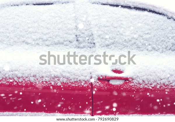 Car in the snow. The windows of the car are covered\
with snow