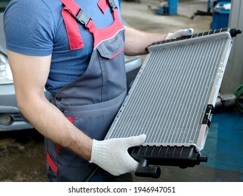 Car Spare Parts. In The Hands Of A Car Mechanic, A New Automobile Radiator Of The Engine Cooling System. Repair And Maintenance In The Service Center.