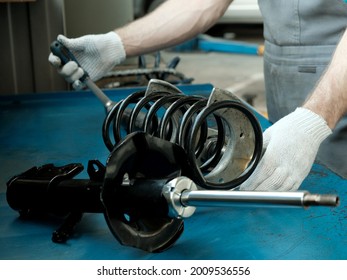 Car Spare Parts.The Mechanic Performs The Work Of Replacing The Spring And Shock Absorber Of The Front Suspension Strut Of The Car.Repair And Maintenance In A Car Service Station.