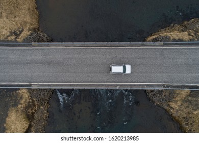 A Car Speeding Across A Bridge Shot From Above Looking Down