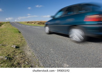 Car Speeding On Empty Road. Dartmoor, UK.