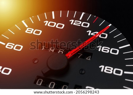 Car speedometer. Auto car speedometer shows 140 km h or miles.Closeup shot,dark black background.Automobile dangerous speed concept