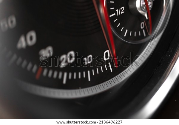 Car speedometer with red indicator close-up\
view, luxury car interior\
background
