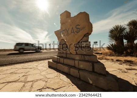 A car speeds along past the Texas border sign from New Mexico near Carlsbad in the USA
