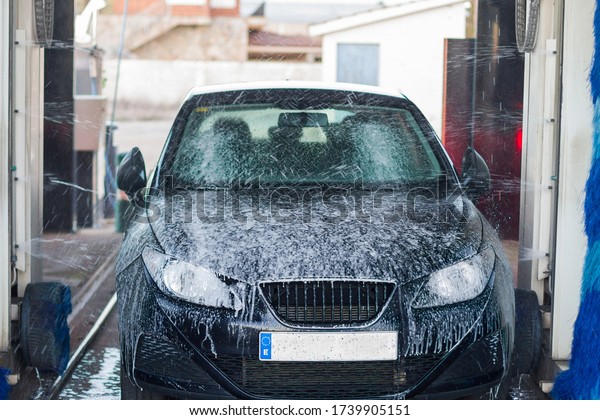 Car\
splashed with soap. Tunnel Car Wash Automatic Car\
