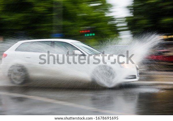 Car splashes water\
on a rainy day, Sweden.