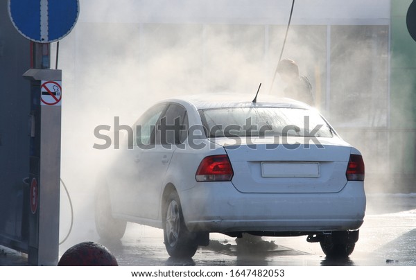 Car in spray\
of water at a self-service car\
wash