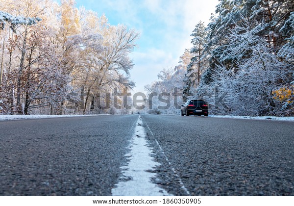 The car is\
standing on the side of the road on a snowy road in the woods.\
Winter track during the first\
snow.