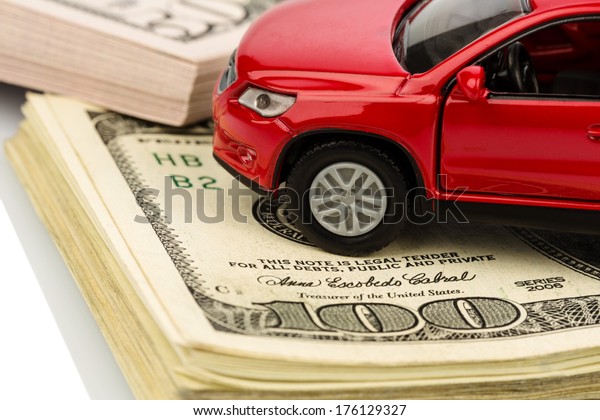 a car stands on dollar\
banknotes. cost of buying a car, fuel, insurance and other car\
costs