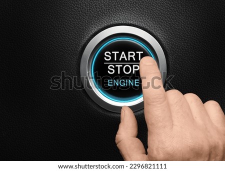 Car start stop engine button with blue glow light. Closeup finger about to press a power button on black leather dashboard. Copy space