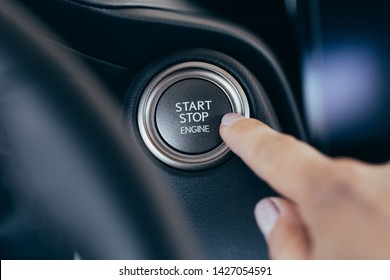Car start stop system with finger pressing the button, horizontal image 
