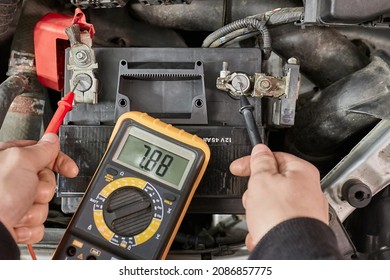 Car starter battery voltage measured with multimeter in a repair garage, bettry dead, time to replace