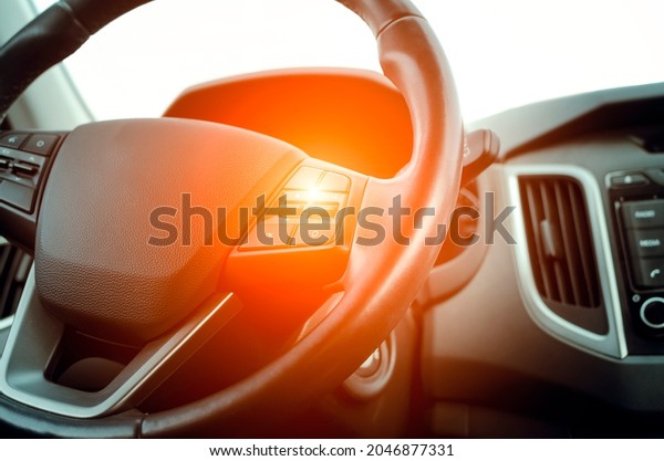 Car\
steering wheel, close-up. Tinted photo,\
sunlight.
