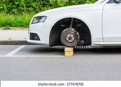 Car With Stolen Wheels. White Vehicle Left On Wooden Bricks.