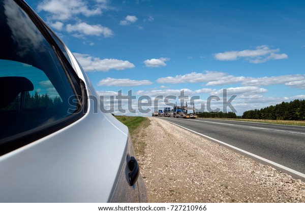 Car stop on the\
roadside.\
Horizontally. The rear side of the car stopped at the\
side of the road.