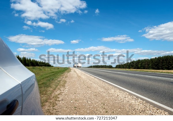 Car stop on the\
roadside.\
Horizontally. The rear side of the car stopped at the\
side of the road.