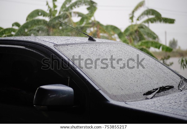 Car stops\
in the rain, Car\'s windshield rain\
wiper